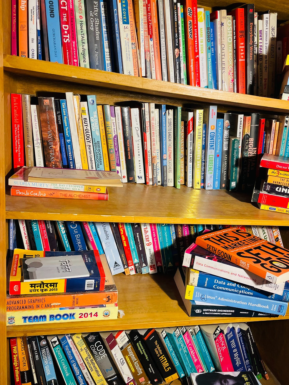 Bookshelf with mixed Hindi and English titles, programming books